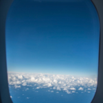 img_9492 - NubianBiz | African Business Directory, Jobs, Marketplace & Entrepreneur Insights Blue sky and white clouds seen through an airplane window framed by the cabin window.